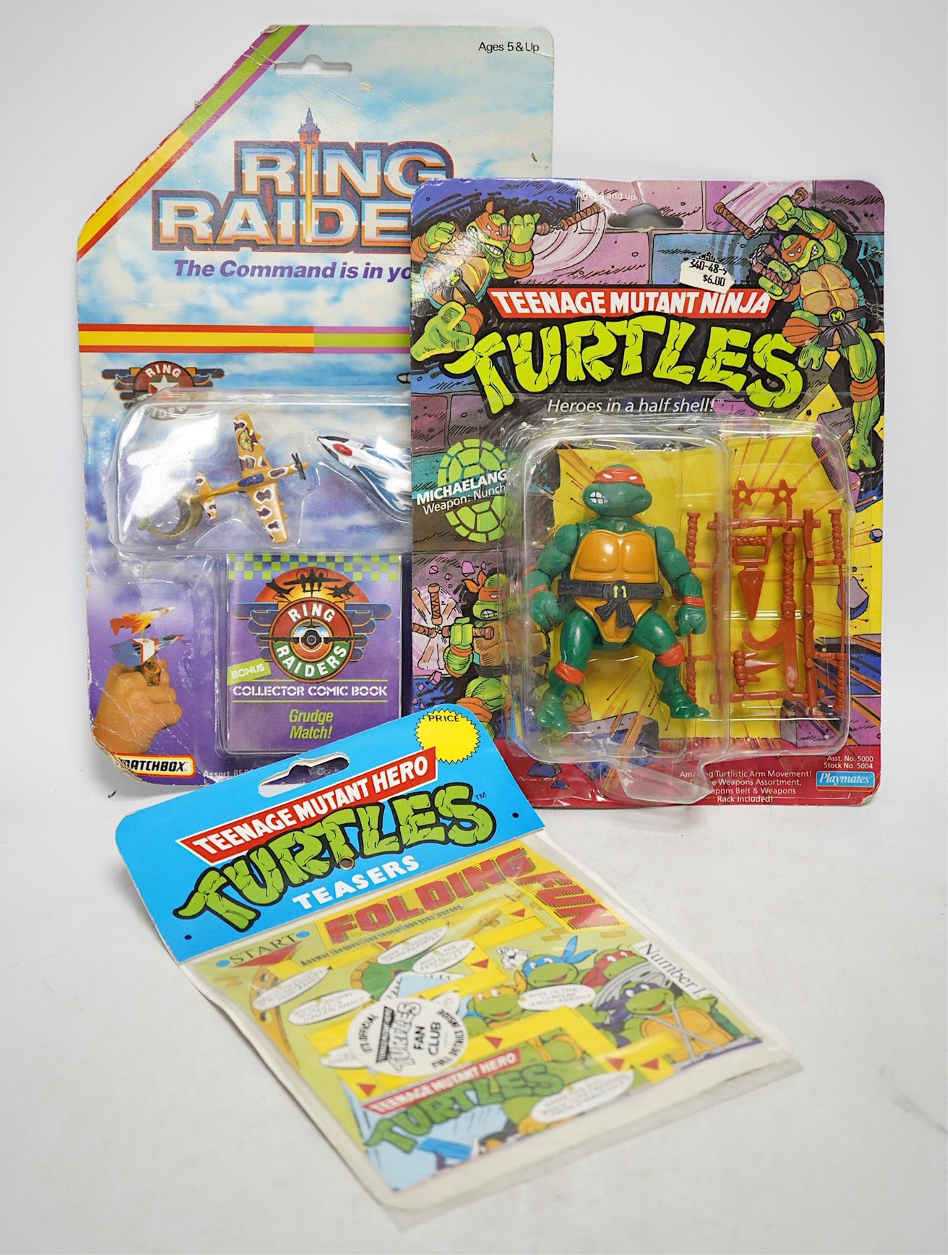 A Playmates Teenage Mutant Ninja Turtles figure of Michaelangelo, dated 1988, a Teenage Mutant Hero Turtles packeted ‘Teasers’, dated 1990, and a Matchbox Ring Raiders toy. Condition - fair to good, some creases to backi